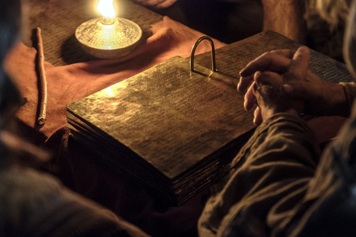 Lehi studies the brass plates with his family. Image via churchofjesuschrist.org.